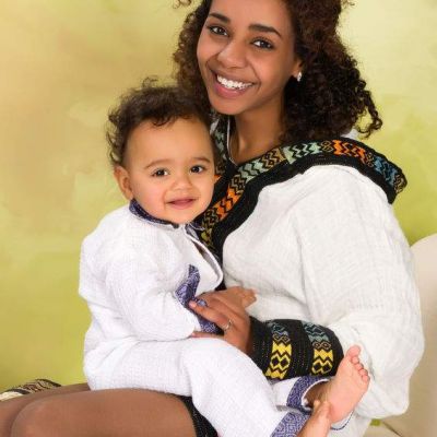 Ethiopian mother in national costume from her country playing with her baby